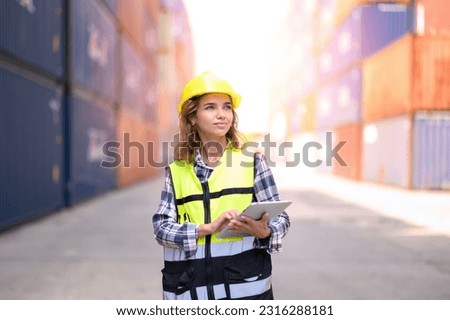 Engineer women wear yellow helmets and reflection shirts working on tablet computers to check inventory details of containers box. Inspector or Safety Supervisor in Container Terminal Royalty-Free Stock Photo #2316288181