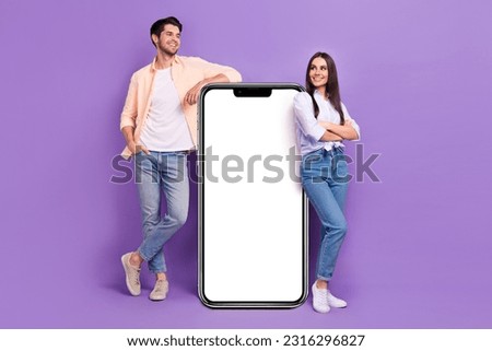 Full size photo of two people showing empty space huge smart phone touchscreen isolated on violet color background
