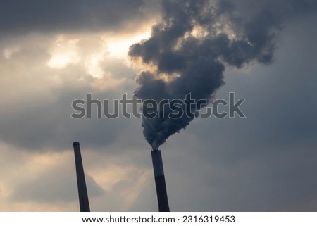 An industrial plant blowing dark smoke into the atmosphere