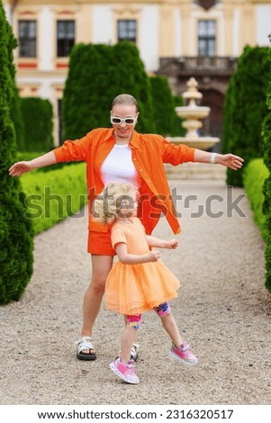 Mom and daughter are walking in the garden, play and make fun