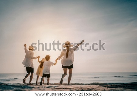 Happy Asian family consisting of father, mother, Son and daughter having fun playing on the beach during summer vacation on the beach. Happy family and vacation concept.