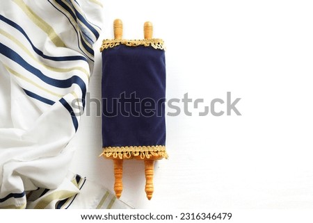 Torah scroll with Tallit on a light background Royalty-Free Stock Photo #2316346479