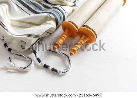 Torah scroll with Tallit on a light background Royalty-Free Stock Photo #2316346499
