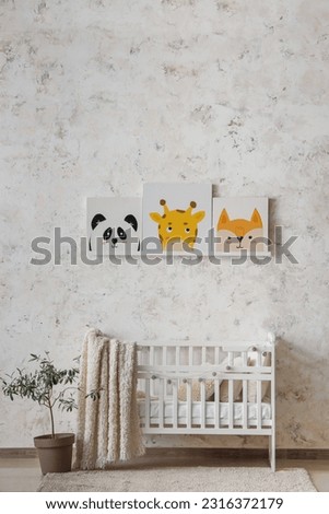 Stylish interior of children's room with baby bed and paintings
