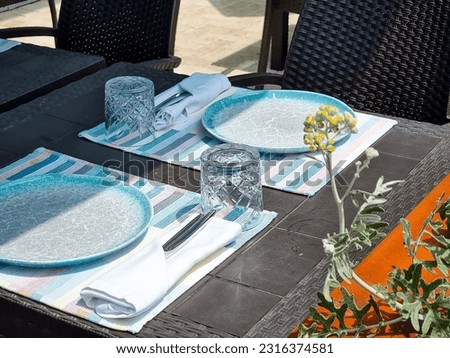 Tables with white tablecloth and chairs in restaurant, glasses on table.Empty cafe tables on veranda of restaurant.leisure, travel and tourism concept - served table at open-air restaurant on beach
