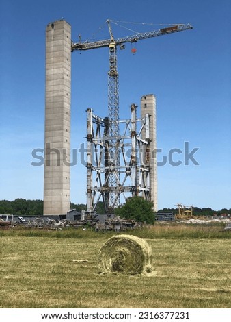 An abandoned industrial building and crane against a cloudless sky