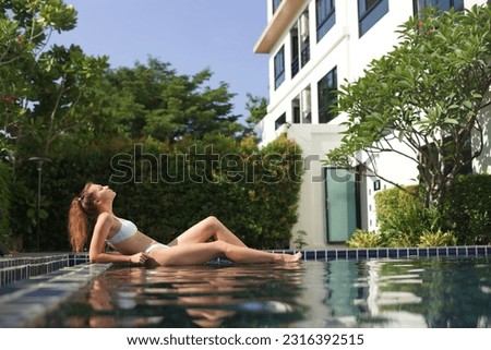 Young happy woman swim in swimming pool, enjoy good sunny weather, summer vacation 
