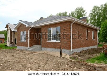 One-story brick house. Construction of low-rise buildings for further sale. Concept of building business. Royalty-Free Stock Photo #2316412691