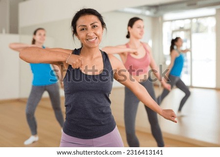 Young adult colombian woman dancing during group class in dance center