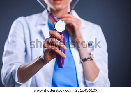 A young female doctor listening , holding stethoscope