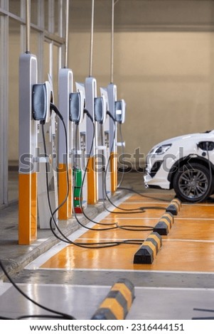 EV charging an electric car. Power supply for electric car charging. Socket for electrical car battery charger. EV car charging station in parking. Nature energy, Clean energy, Green eco concept. Royalty-Free Stock Photo #2316444151