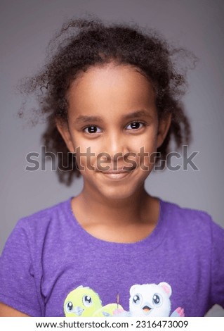 Captivating studio portrait of a young Ethiopian girl radiating pure joy, as she indulges in playful silliness and showcases her delightful expressions on a white seamless backdrop. Royalty-Free Stock Photo #2316473009