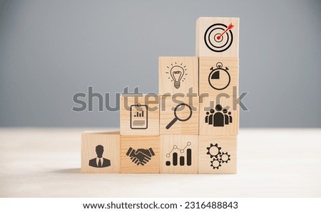 Wooden block cude step on a table with Action Plan, Goal, and Target icons. Success and business target concept. Project management and company strategy for financial growth.