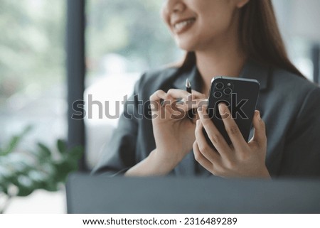 Woman holding a mobile phone and surfing the internet, executing apps on smartphone, answering emails and texting with colleagues. The concept of using technology in communication.