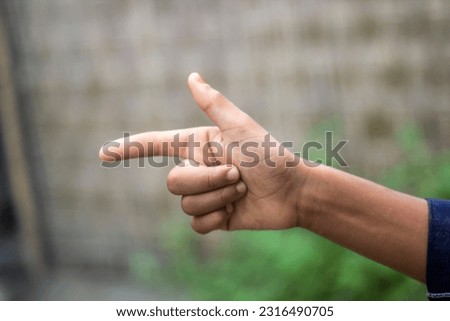A man shows two fingers of his hand and the background is blurred
