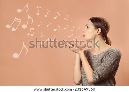 Music for you, Pretty young girl blowing notes 