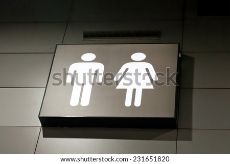 toilet sign with male and female on grey wall