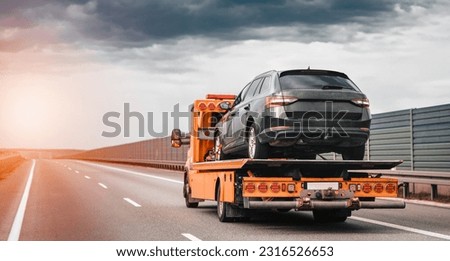 Tow truck with a broken car on a road. Tow truck transporting car on the highway. Car service transportation concept. Roadside Rescue. Royalty-Free Stock Photo #2316526653
