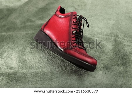 red women's boots on green background