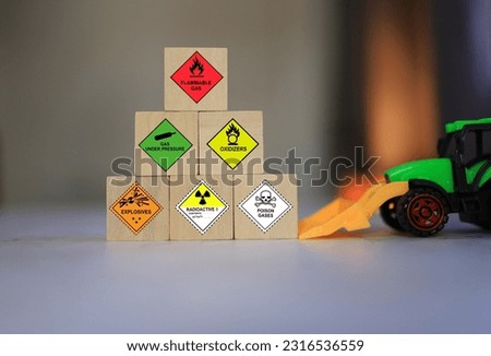 Hazard materials sign on the wooden block or wooden cube coution and warning sign for dangerous goods.