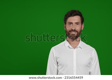 Chroma key compositing. Handsome man smiling against green screen