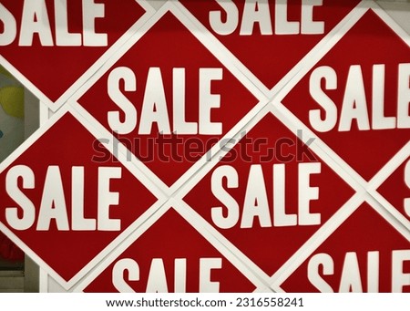 A closeup of SALE stickers in a shopping mall