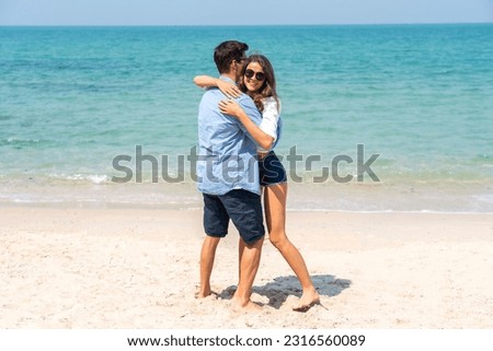 Vacation romantic love young happy smile couple in honeymoon travel holiday trip standing on sand at blue sky sea beach having fun and relaxing together on tropical beach.Summer travel