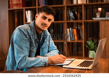 A male college student studying in a university library.