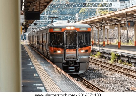 Local train arrive to railway station platform in Japan. Royalty-Free Stock Photo #2316571133
