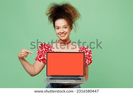 Young happy IT woman she wearing casual clothes red blouse hold use working point finger on laptop pc computer with blank screen workspace area isolated on plain pastel light green color background