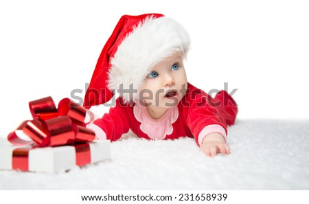 Beautiful little baby celebrates Christmas. New Year's holidays. Baby in a Christmas costume with gift. Isolated