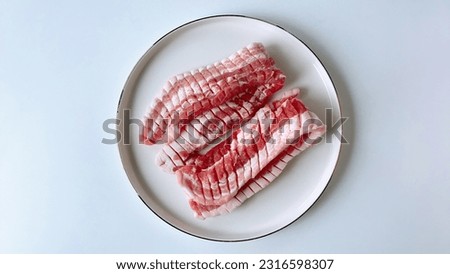 a picture of raw pork on a plate before roasting it