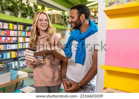 Cute woman and dark-skinned man standing in the library