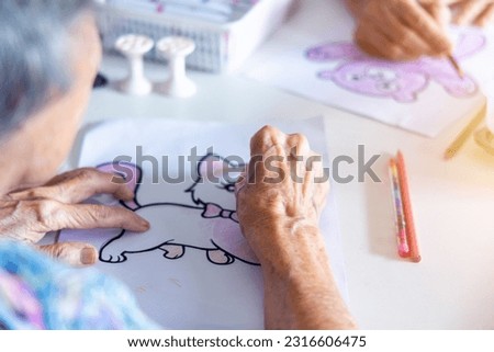 Elderly people painting works of cartoon artwork as a hobby activity for exercise hand and brain.