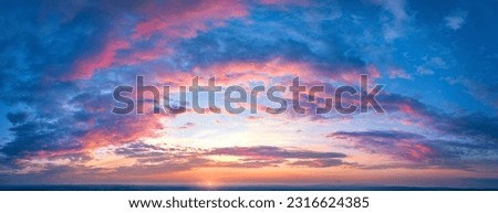 Ideal for Sky replacement project: Panoramic, colorful pink-orange-blue dramatic sky with clouds  illuminated by red sunset, aerial photography, far horizon without obstacles.