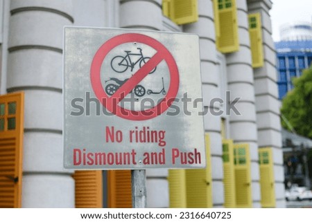 A sign that says no riding dismount and push, Singapore