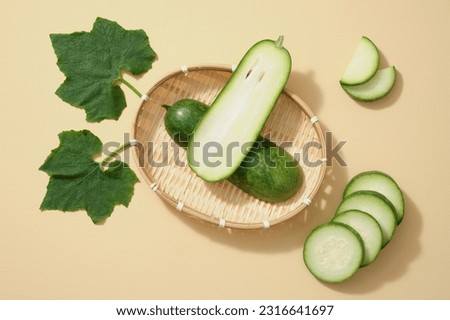 Against a bamboo basket, fresh winter melon cut in half, some slices and leaf of winter melon decorated on a beige background. Winter melon is one of the popular foods in daily meals in Vietnam Royalty-Free Stock Photo #2316641697