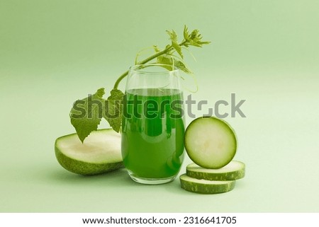 Front view of a glass of juice with fresh winter melon slices and leaf decorated on a light green background. Drinking winter melon tea regularly helps cool the body very well on hot days. Royalty-Free Stock Photo #2316641705