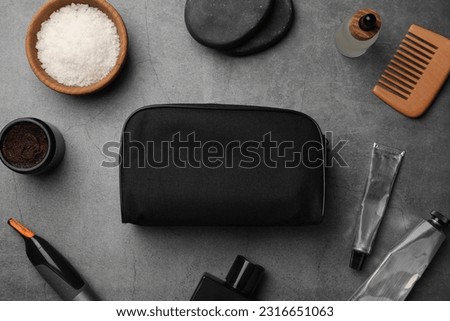 Compact toiletry bag, spa stones and different cosmetic products on grey textured background, flat lay Royalty-Free Stock Photo #2316651063