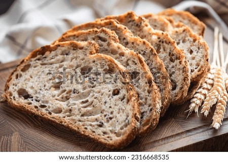 Multi grain sourdough bread with flax seeds cut on a wooden board, closeup view. Healthy vegan bread choice Royalty-Free Stock Photo #2316668535