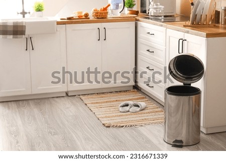 Opened metallic trash bin on floor in modern kitchen Royalty-Free Stock Photo #2316671339