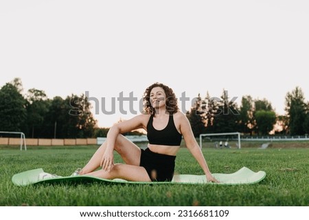 woman in sportswear goes in for yoga sports at the stadium in summer.