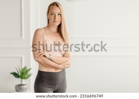 Young healthy beautiful woman in sportive outfit training at home