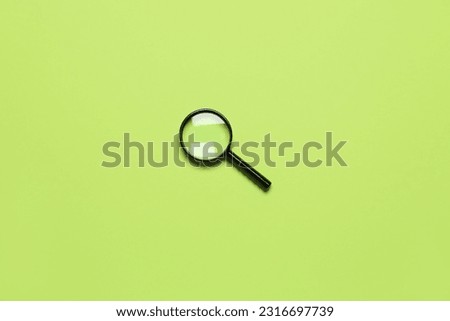 Black mini magnifier on green background