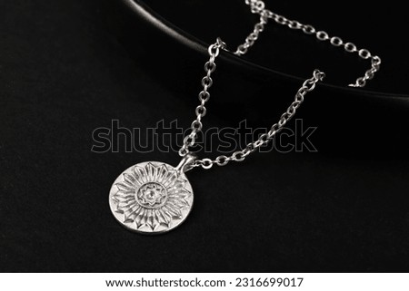 Plate with beautiful chain necklace on black background Royalty-Free Stock Photo #2316699017