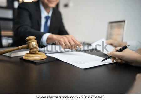 Legal counsel presents to the client a signed contract with gavel and legal law. justice and lawyer concept.