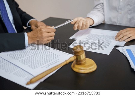 Legal counsel presents to the client a signed contract with gavel and legal law. justice and lawyer concept.