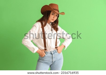 Beautiful cowgirl on green background Royalty-Free Stock Photo #2316716935