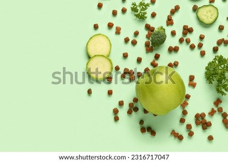 Composition with dry pet food and natural products on green background