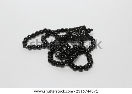 A tasbih that has Arabic writing, namely lailahaillallah and has a white background
